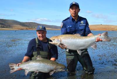 IFS Staff members Storm Eastley and Jonah Yick releasing large Atlantic Salmon into Criagbourne Dam.