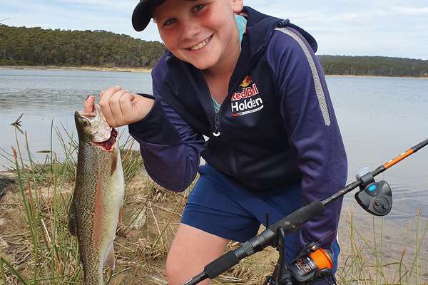 Photos of a junior angler with their catch of a two pound rainbow trout caught at Curries River Reservoir.