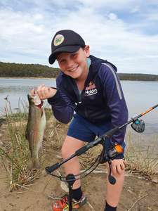 Photos of a junior angler with their catch of a two pound rainbow trout caught at Curries River Reservoir.